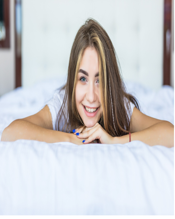 Girl smiling while lying on her bed